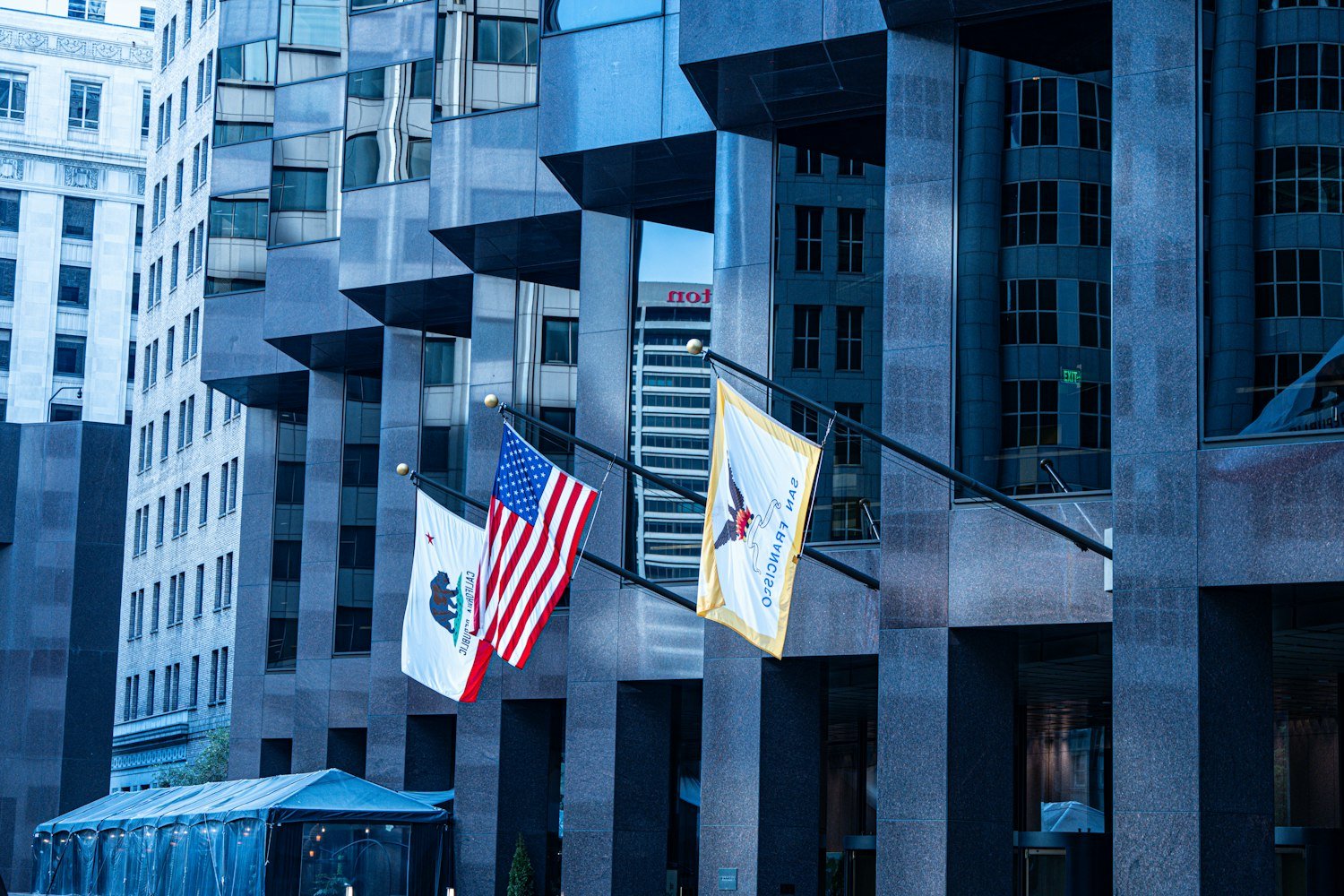 American and state flags outside modern office buildings, where federal and state jobs are based