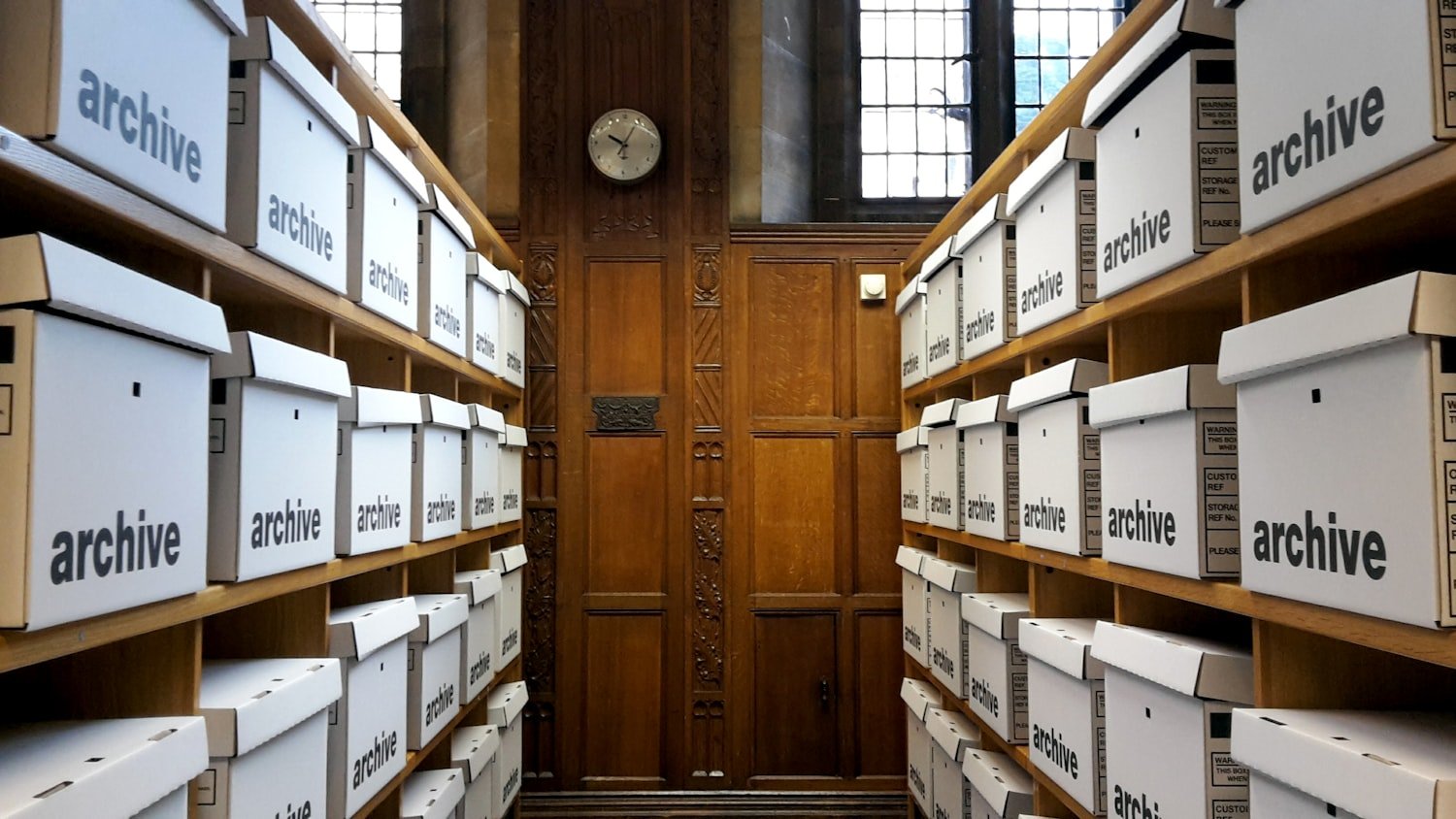 Rows of archive boxes on shelves, as records are stored at the National Personnel Records Center
