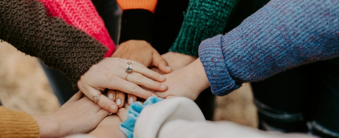 A group stacking their hands together, representing the volunteer spirit of American Legion Auxiliary units
