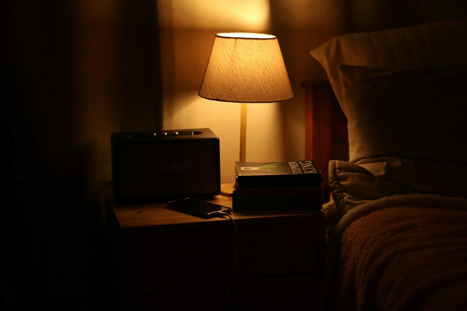 A bedside lamp lighting a nightstand, when tinnitus is most noticeable