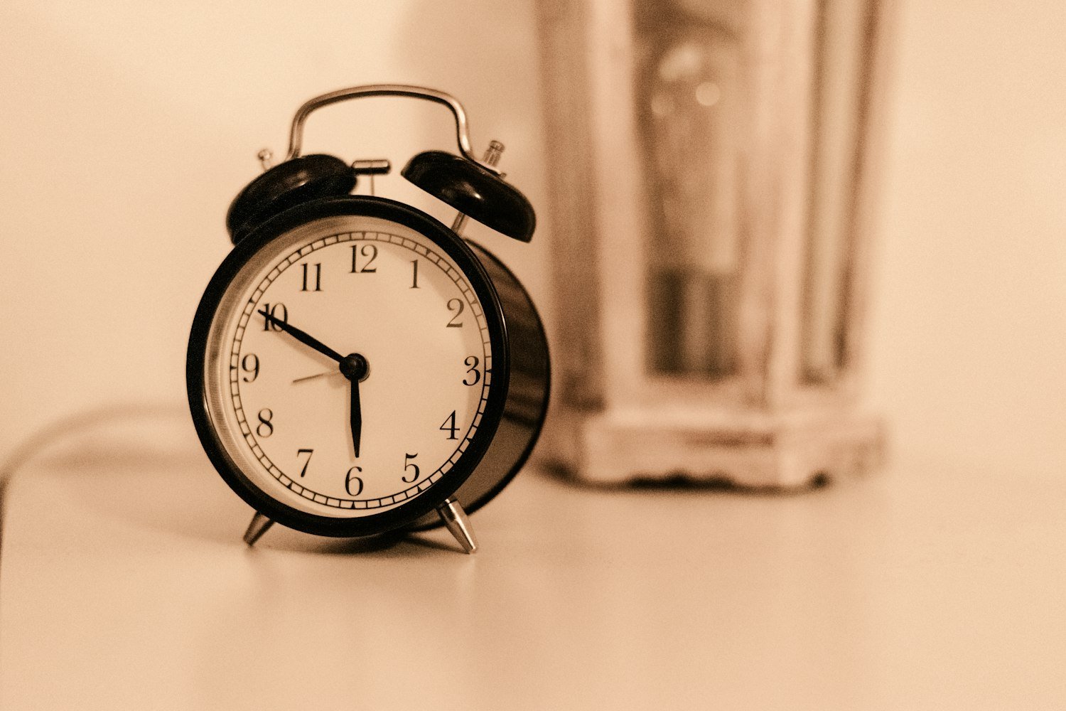 A black alarm clock, marking the early hours sleep apnea interrupts