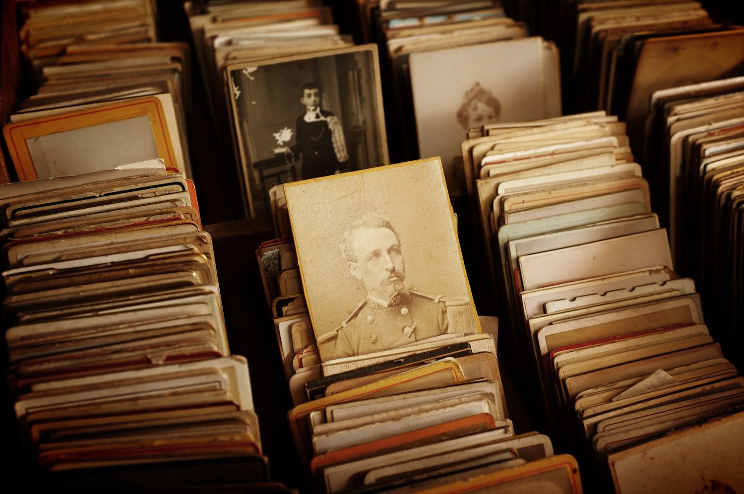 A collection of black and white photographs spread out, as when sorting a family archive