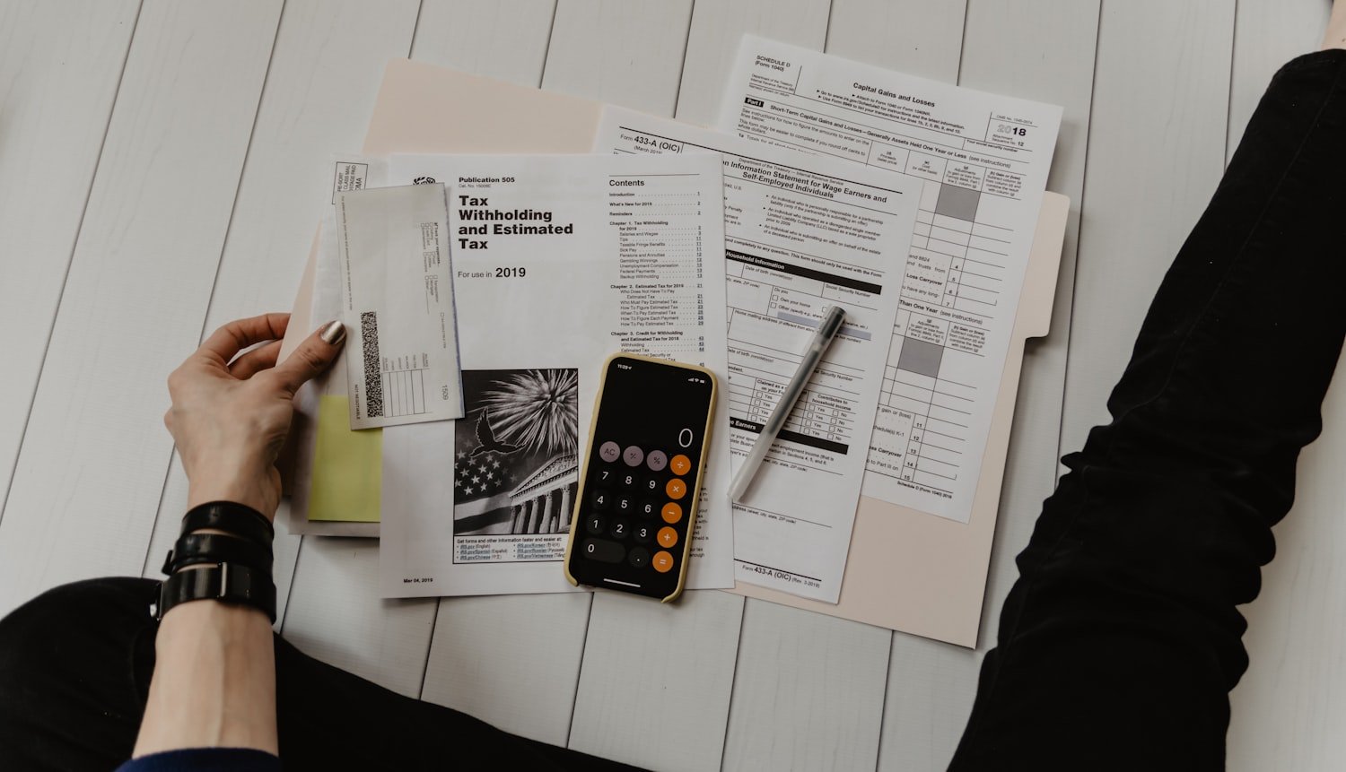 A person reviewing paperwork with a calculator, representing the fees charged by paid claim representatives