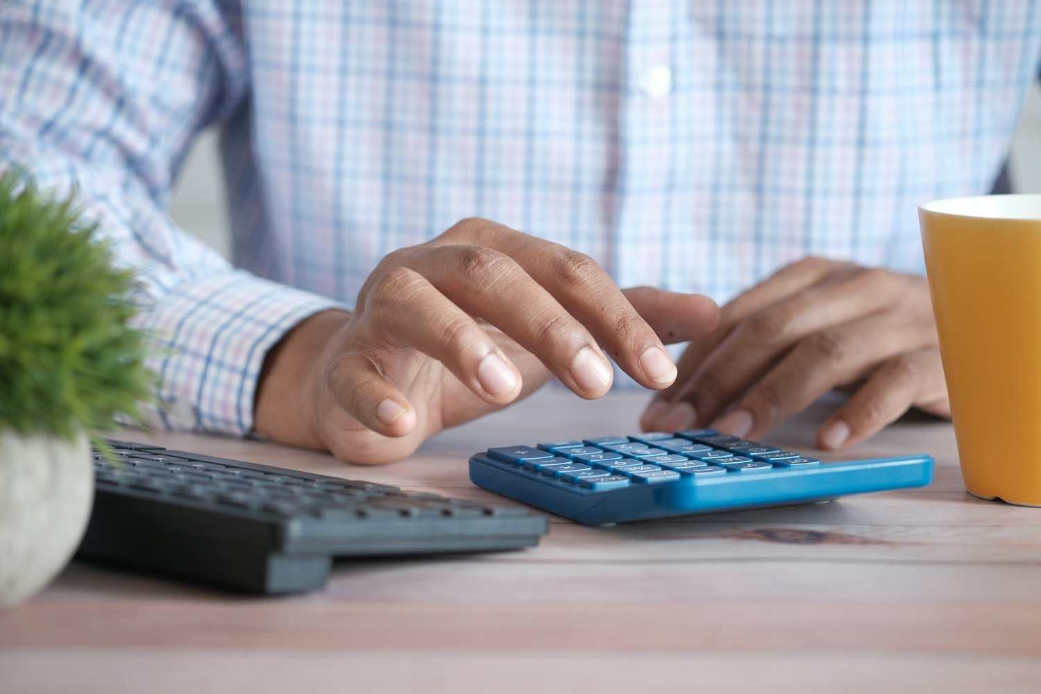 A person using a calculator at a desk, representing the disabled veteran property tax exemption