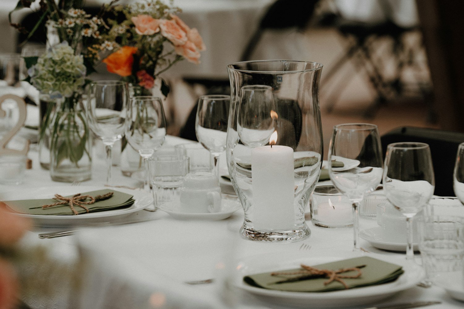 A memorial table setting with a lit candle, used in remembrance ceremonies