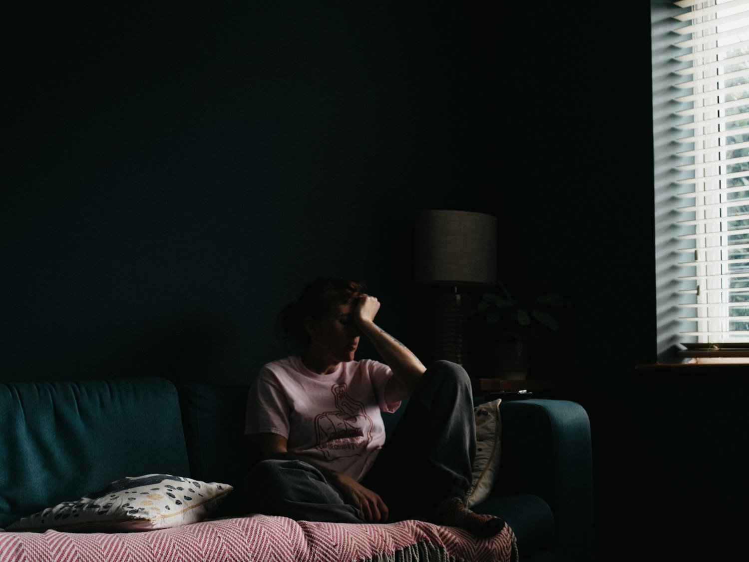 A person resting on a couch, representing caregiver fatigue and the need for respite
