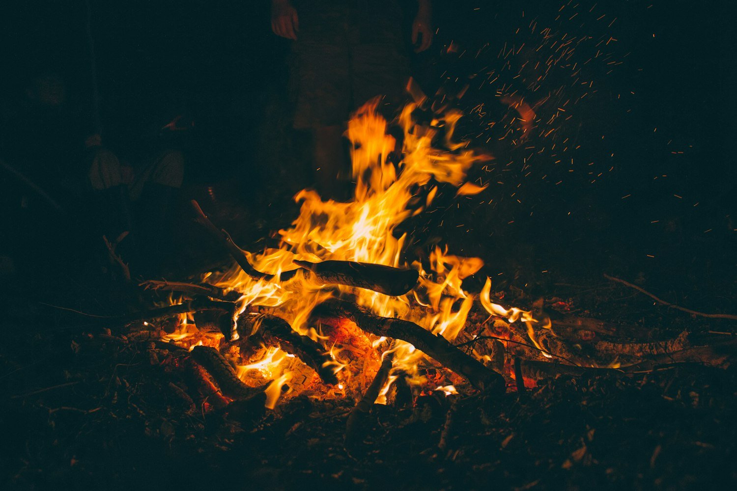 A controlled fire burning at night, as used in a formal flag retirement ceremony