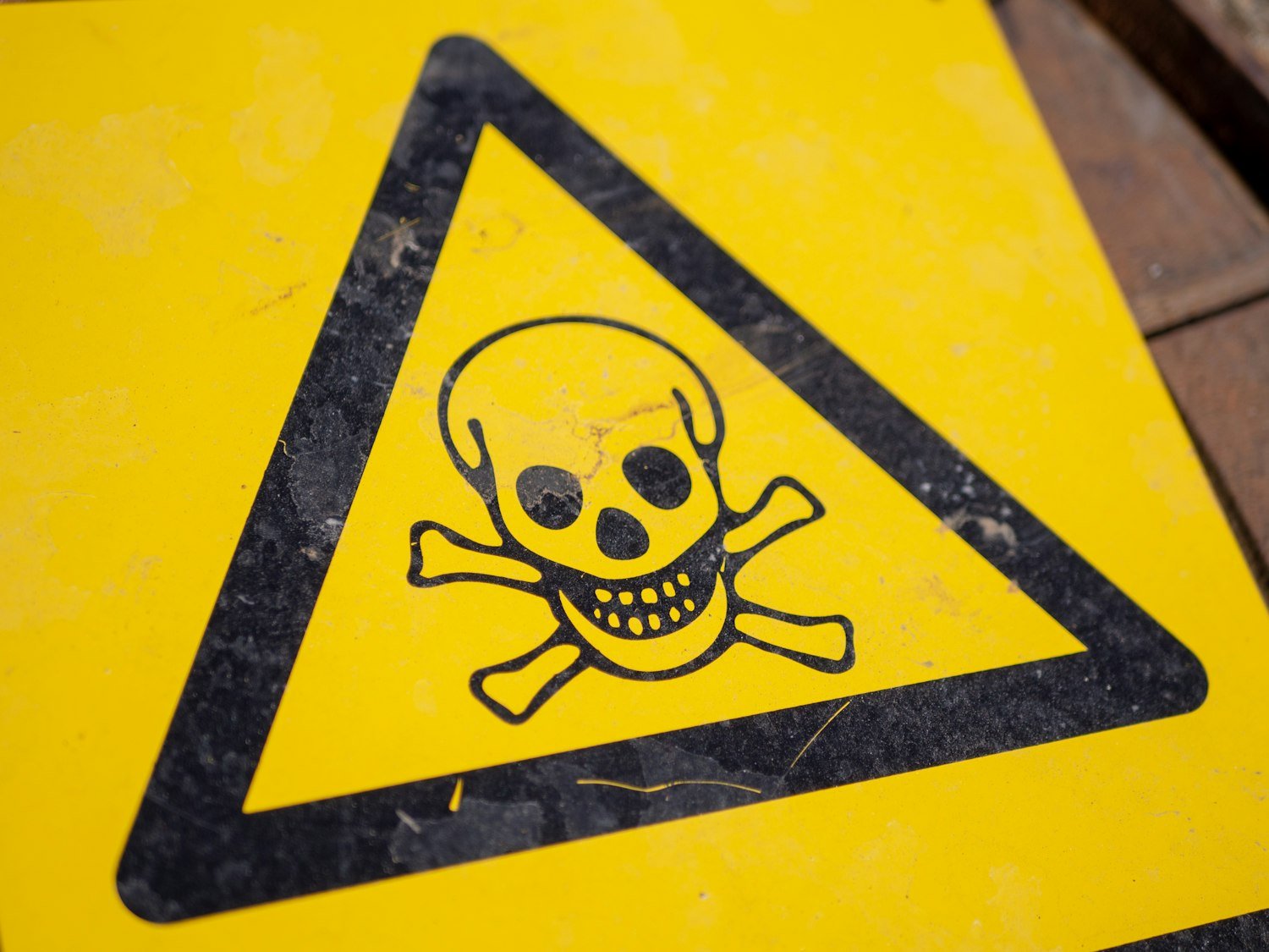 A yellow and black chemical hazard warning sign, representing toxic exposure risks