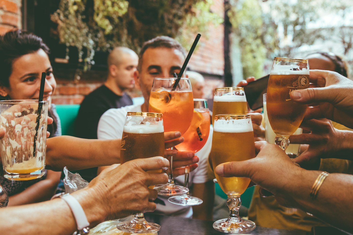 Community members gathered holding drinks together during the day