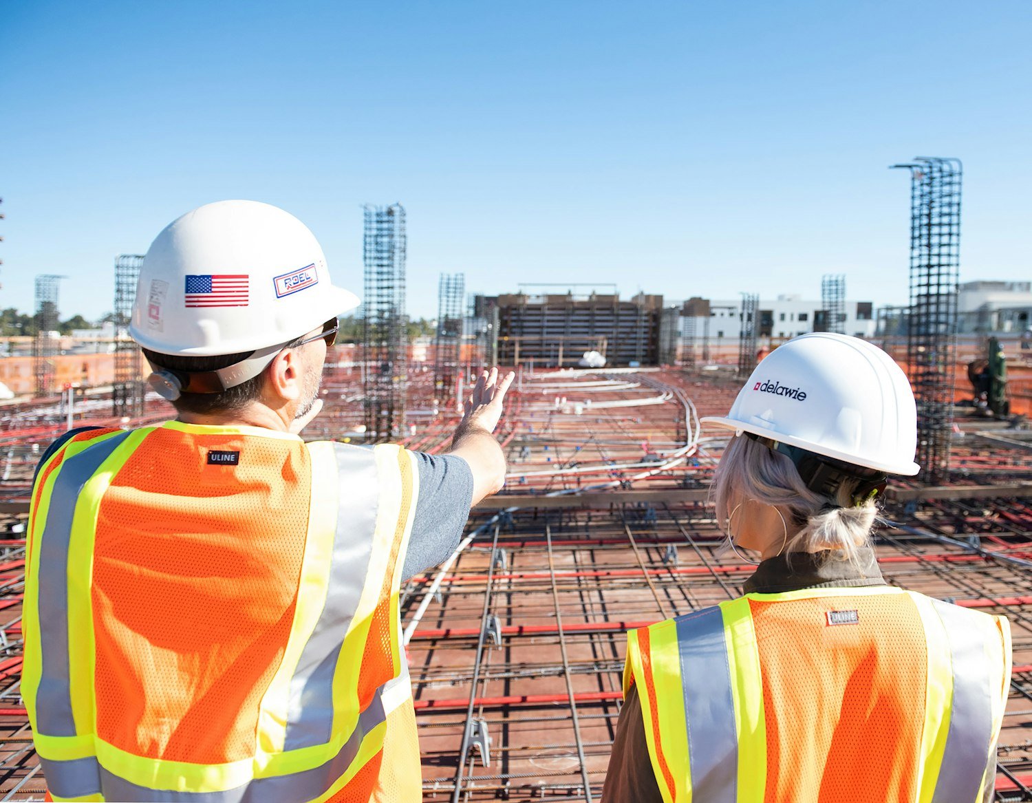 Two construction workers in safety vests at a job site, a common veteran-owned contracting trade