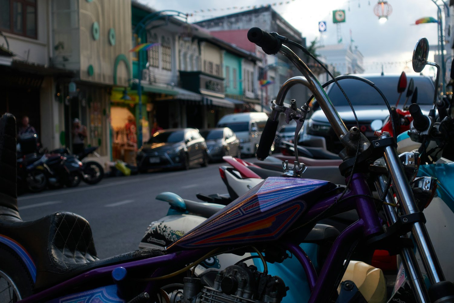 Customized motorcycles lined up parked on a street