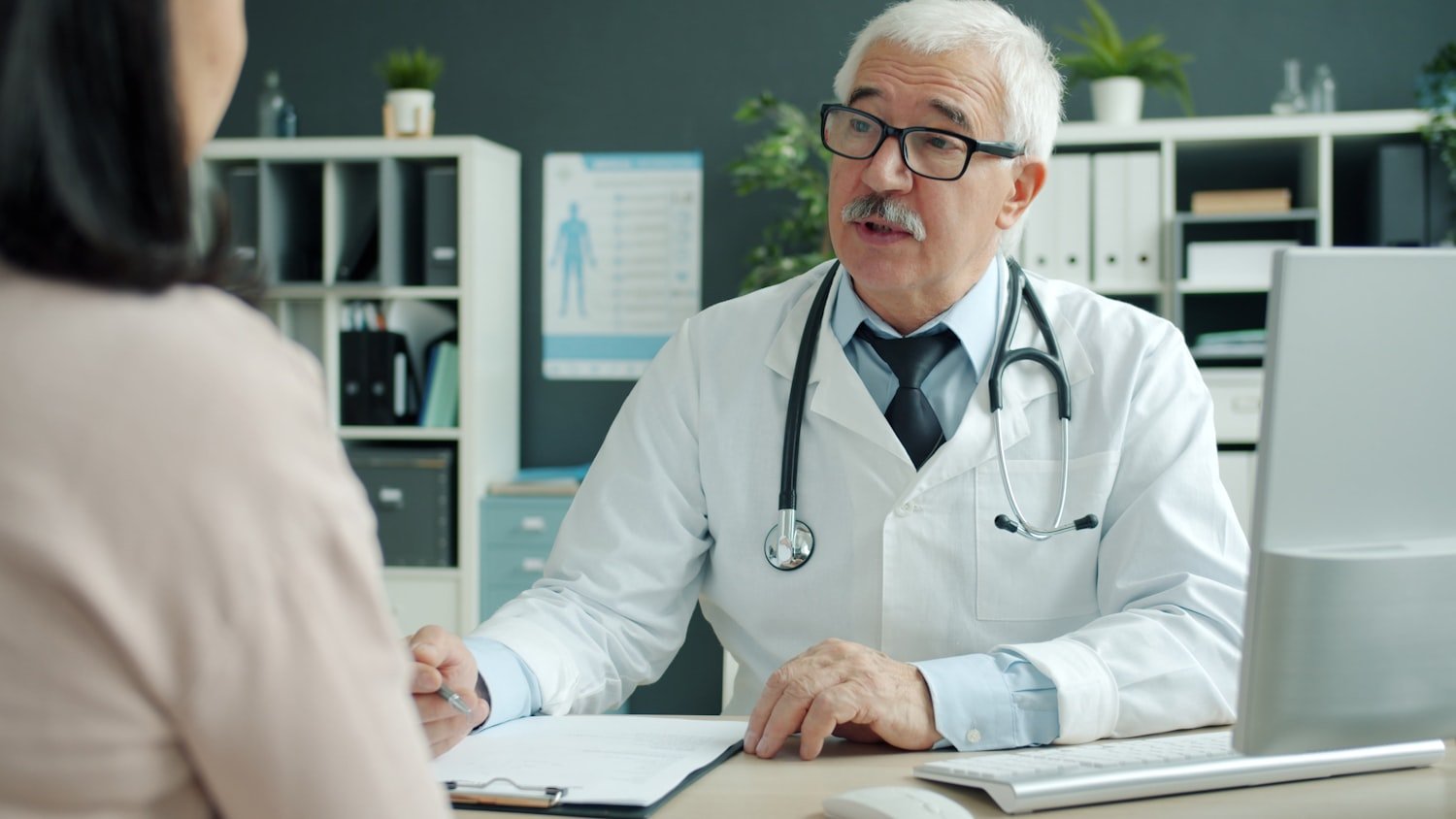 A doctor talking with a patient in an office, where a community care referral begins