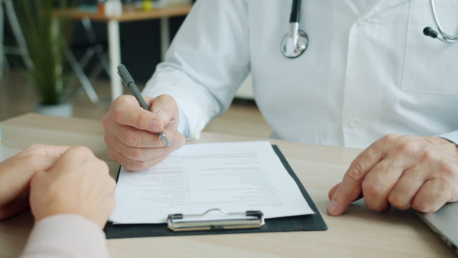 A doctor writing on a patient's chart during a toxic exposure health screening