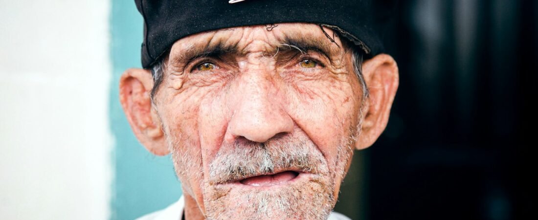 An elderly veteran wearing a black beret, honored on Veterans Day