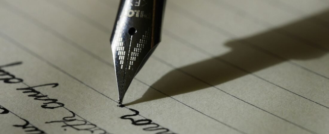 A fountain pen resting on lined paper, evoking Harry Colmery's handwritten draft of the GI Bill