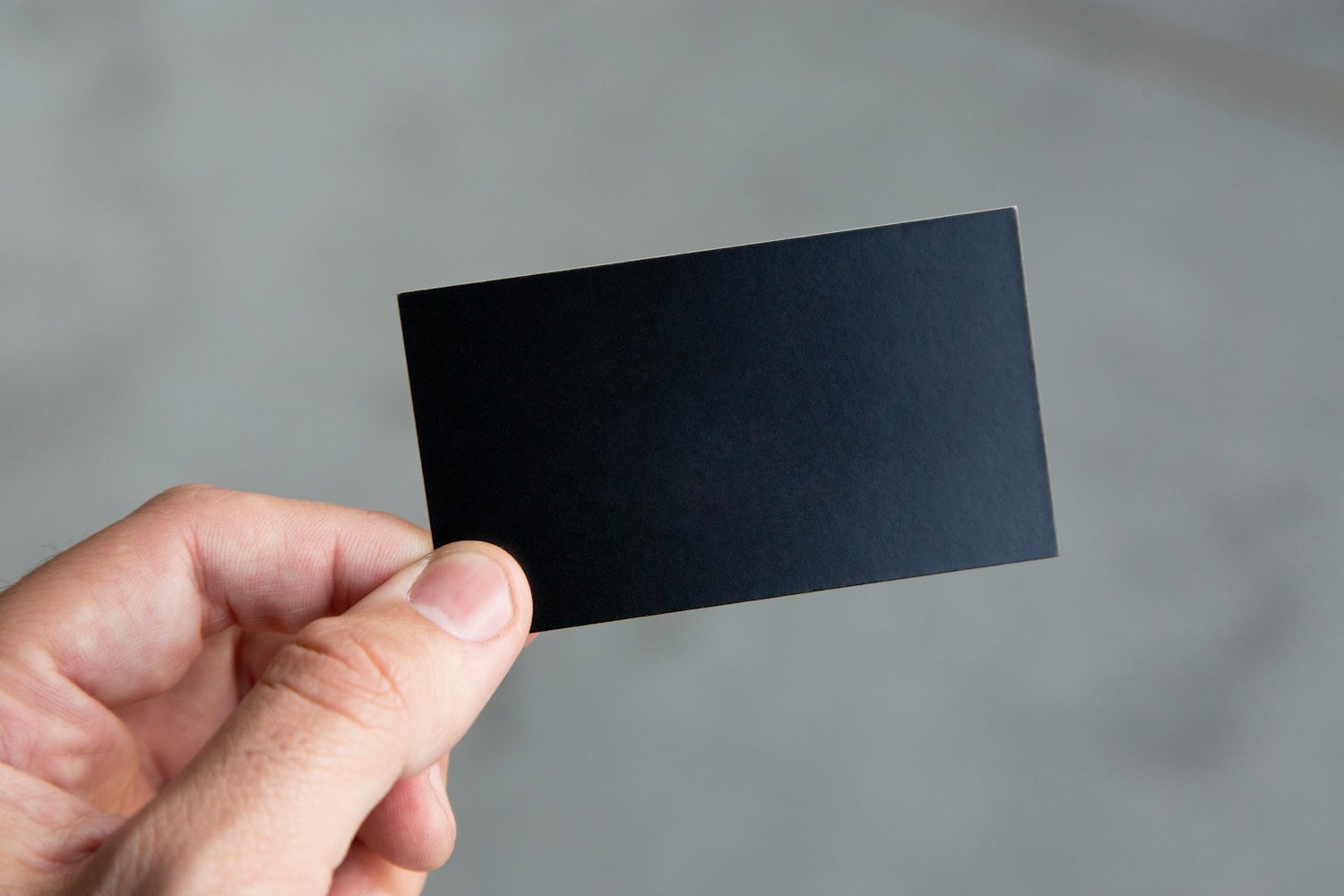 A hand holding a card, as when presenting identification
