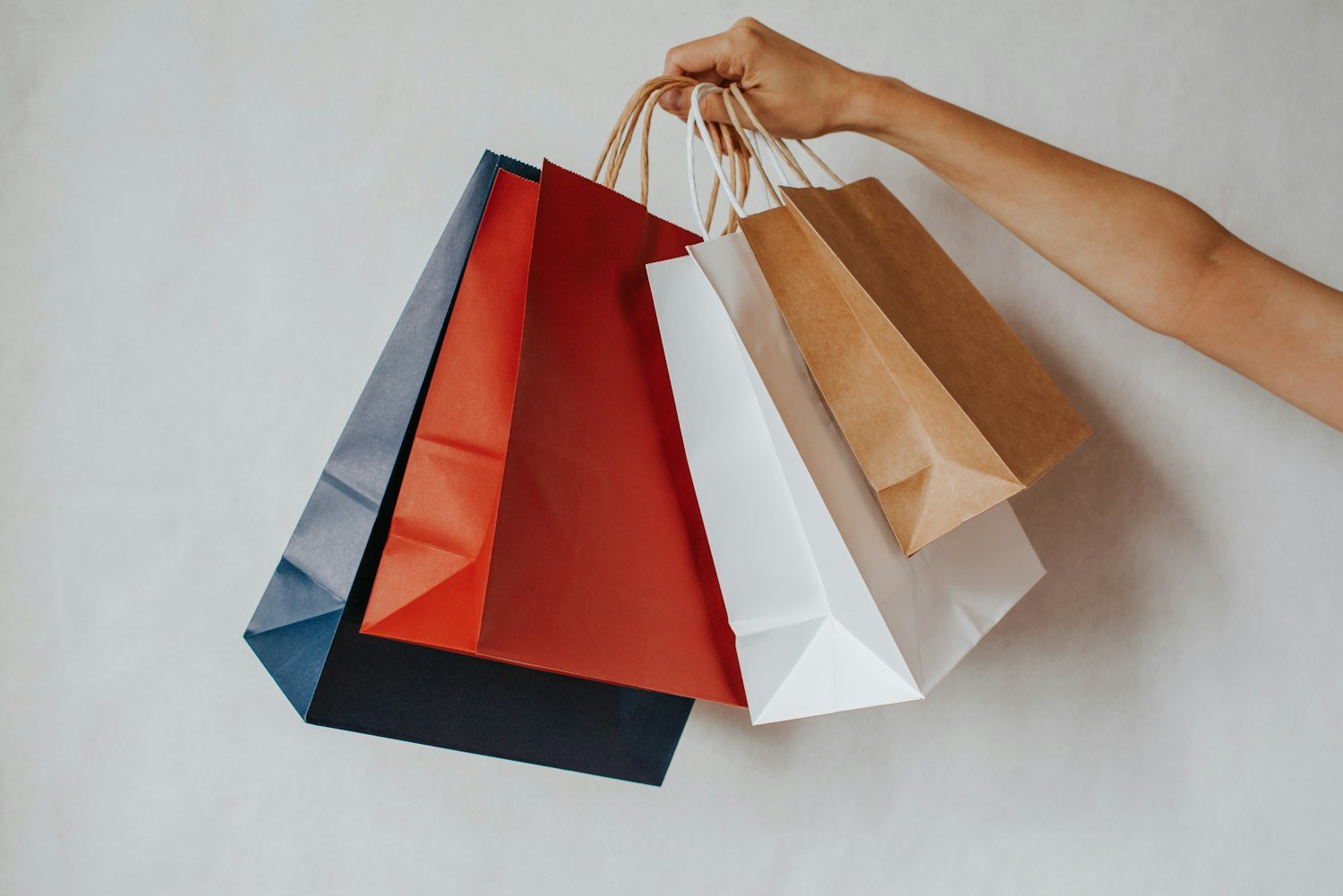 A hand holding shopping bags, representing tax-free exchange purchases