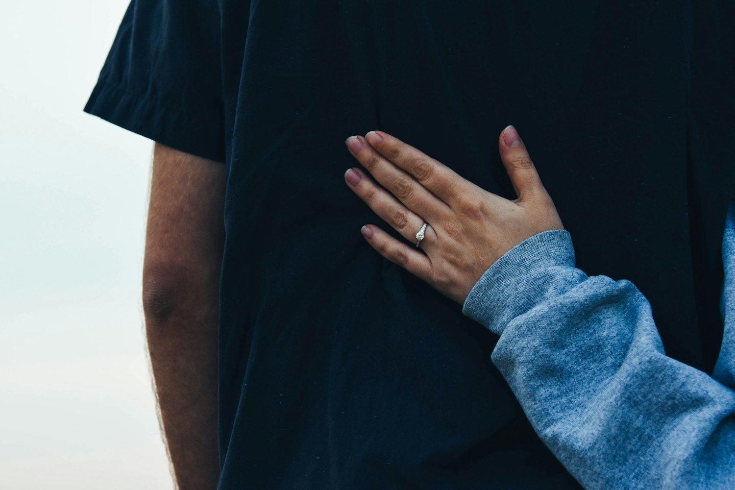 One person resting a supportive hand on another's shoulder