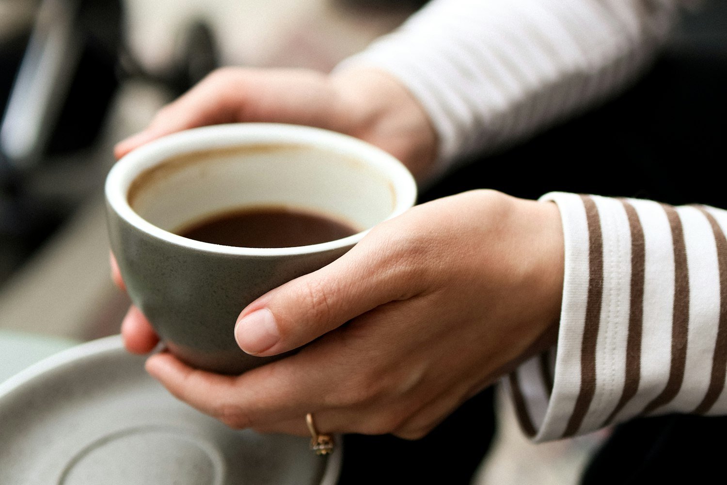 Hands holding a warm cup of coffee, an ordinary morning routine