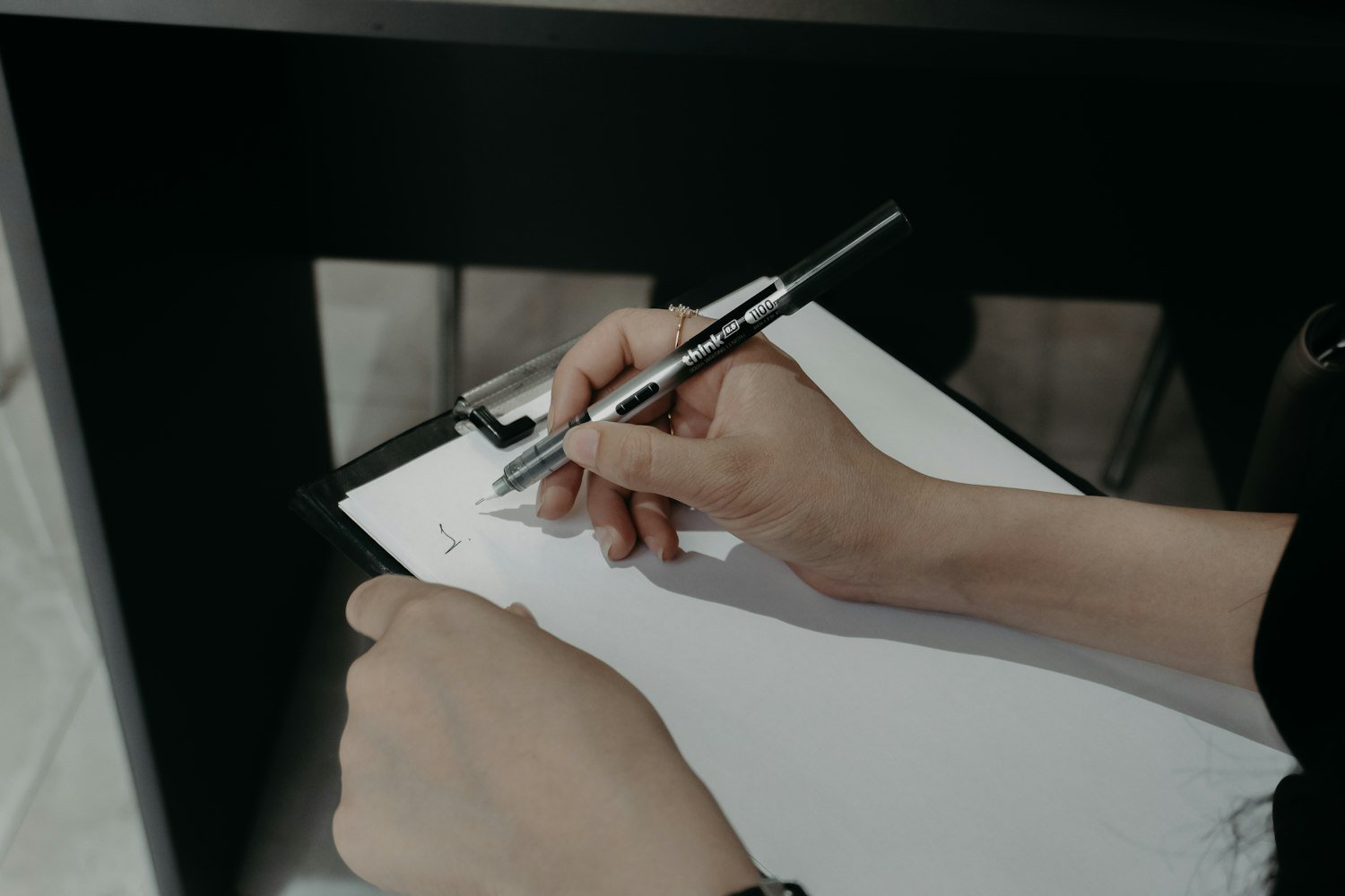 Hands writing on a clipboard, as when completing VA Form 21-8940