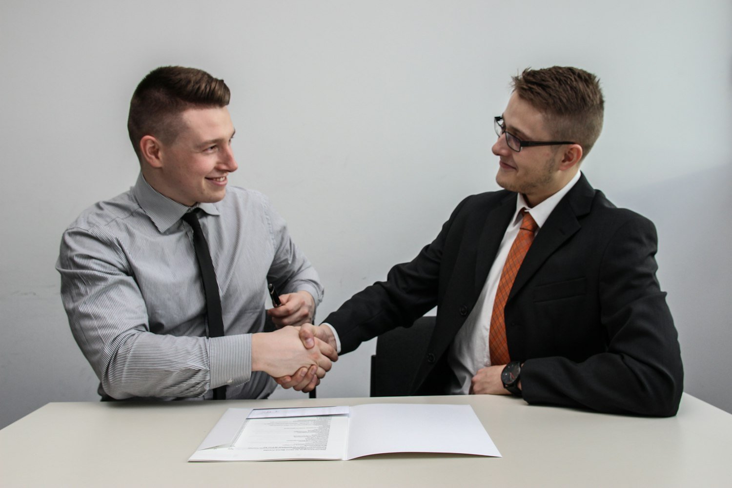 Two people shaking hands, representing a contract award