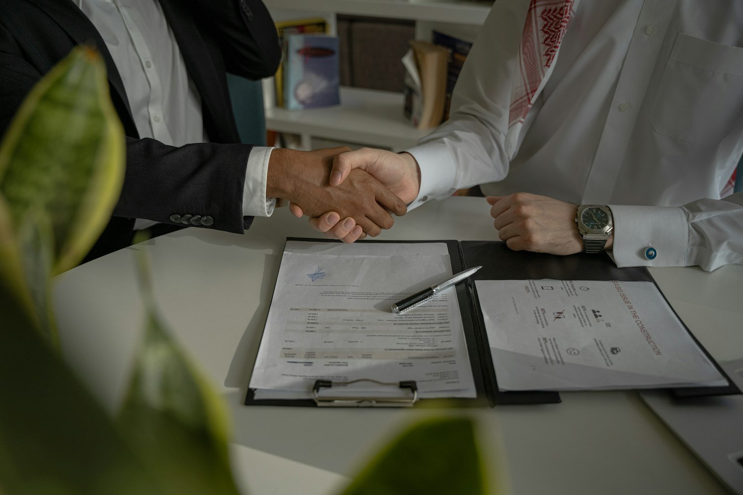 Two people shaking hands over paperwork, representing a federal job offer