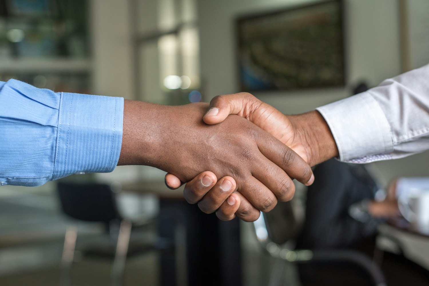 Two people shaking hands, as when a new member is welcomed at a post meeting