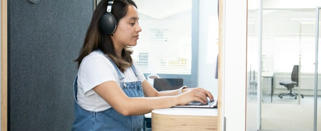 A person wearing headphones at a desk, as during a puretone audiometry hearing test