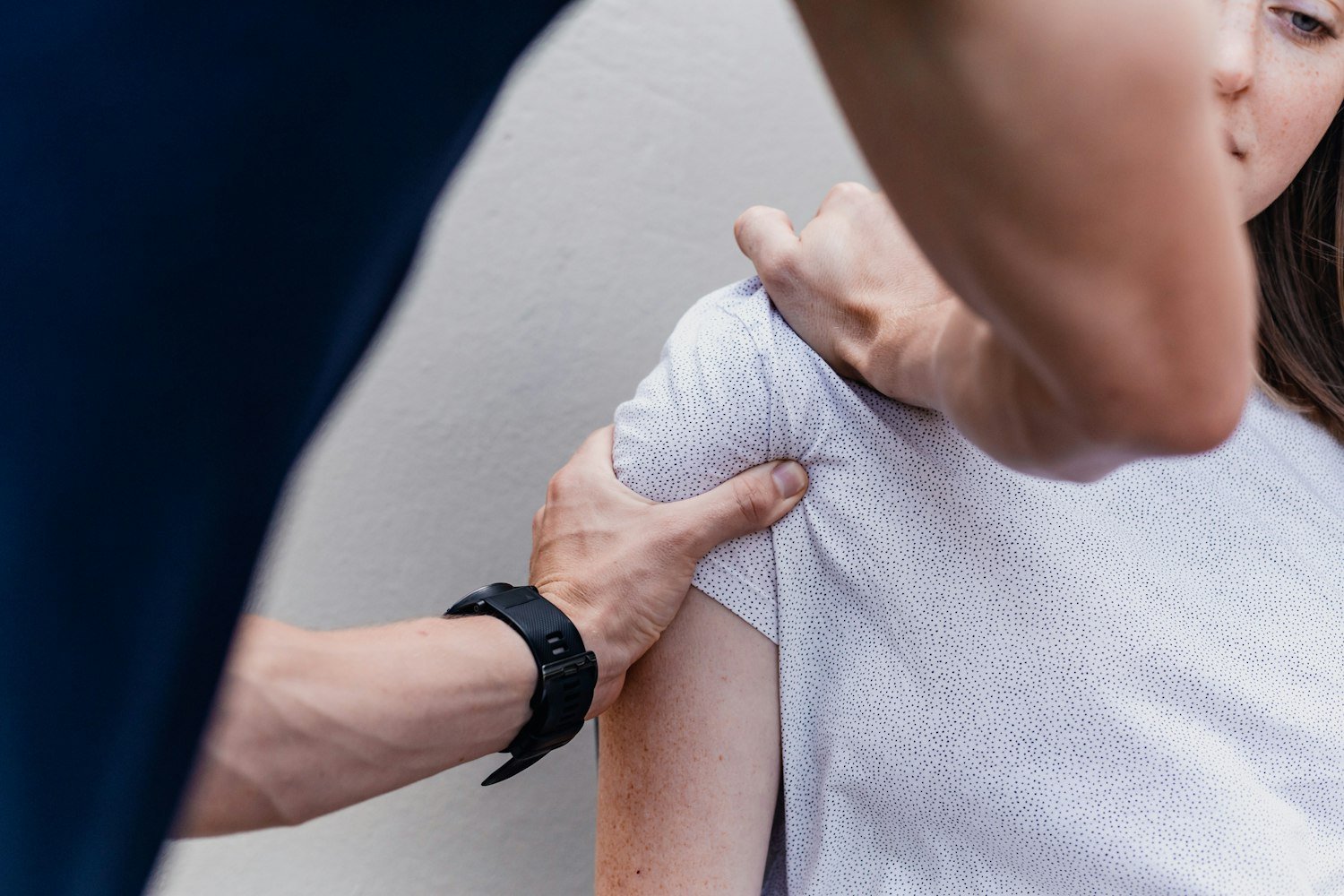 One person holding another's arm in a gesture of reassurance and connection