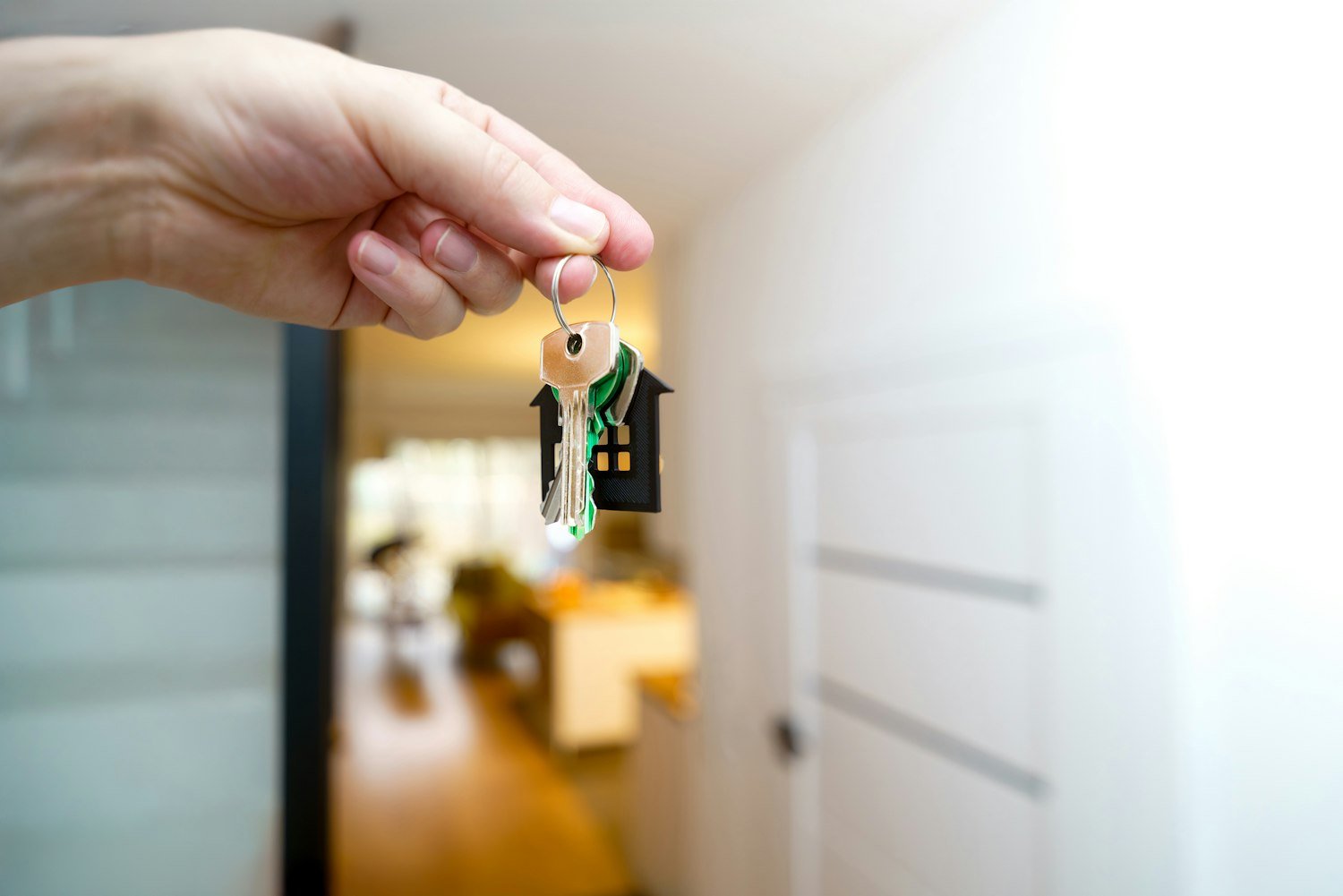 Someone holding house keys at the entrance of a home after closing