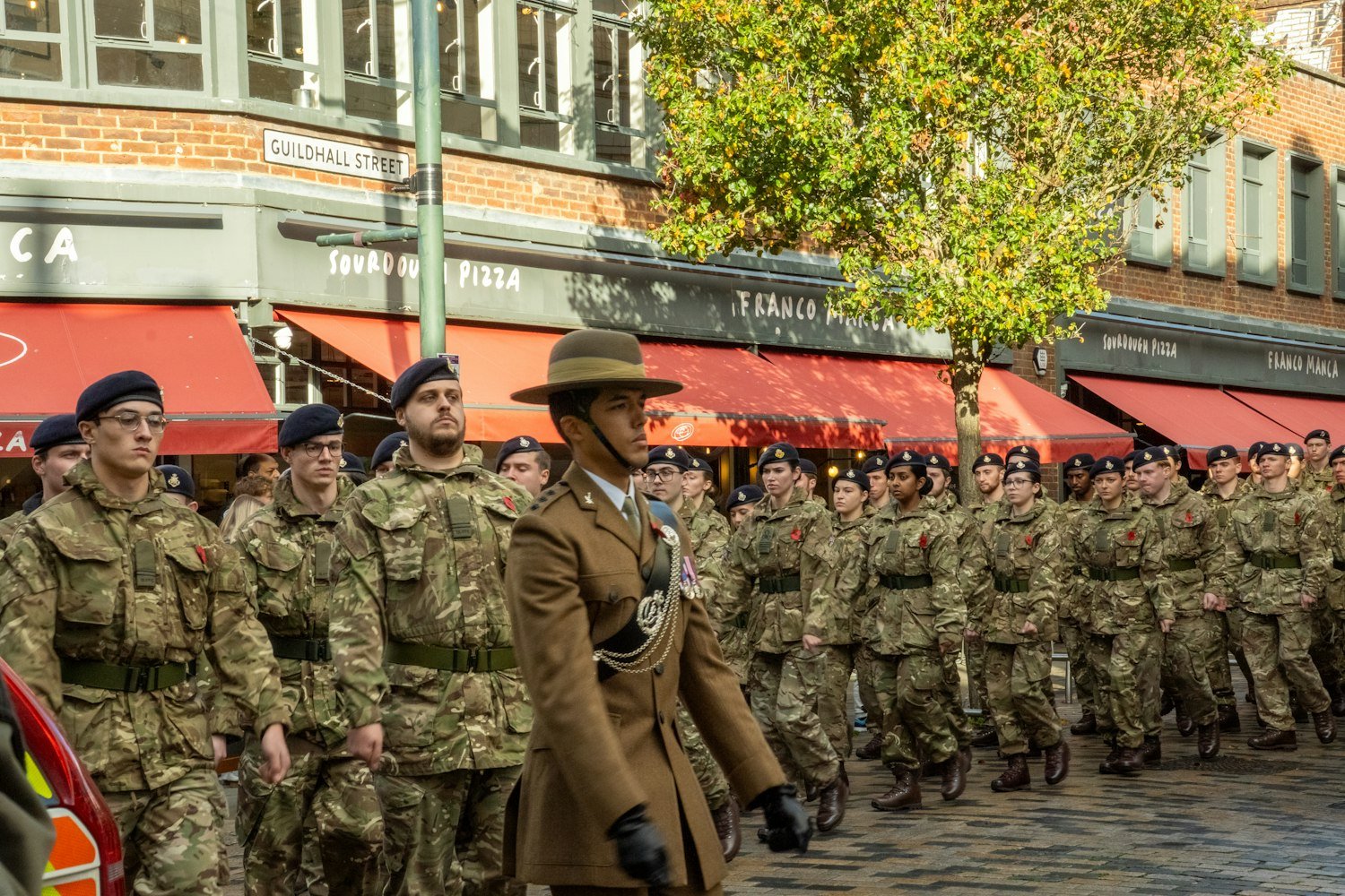 Soldiers in uniform marching in a street parade
