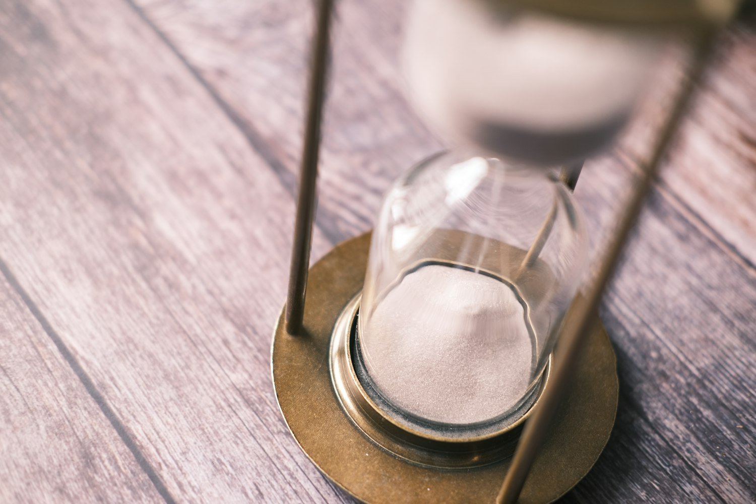 An hourglass on a wooden table, representing the 240-day conversion deadline
