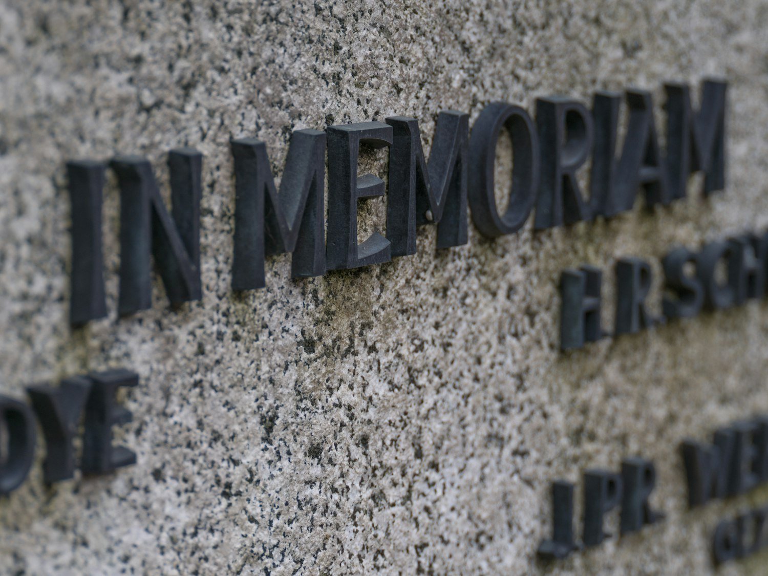 An In Memoriam inscription carved into a granite memorial wall