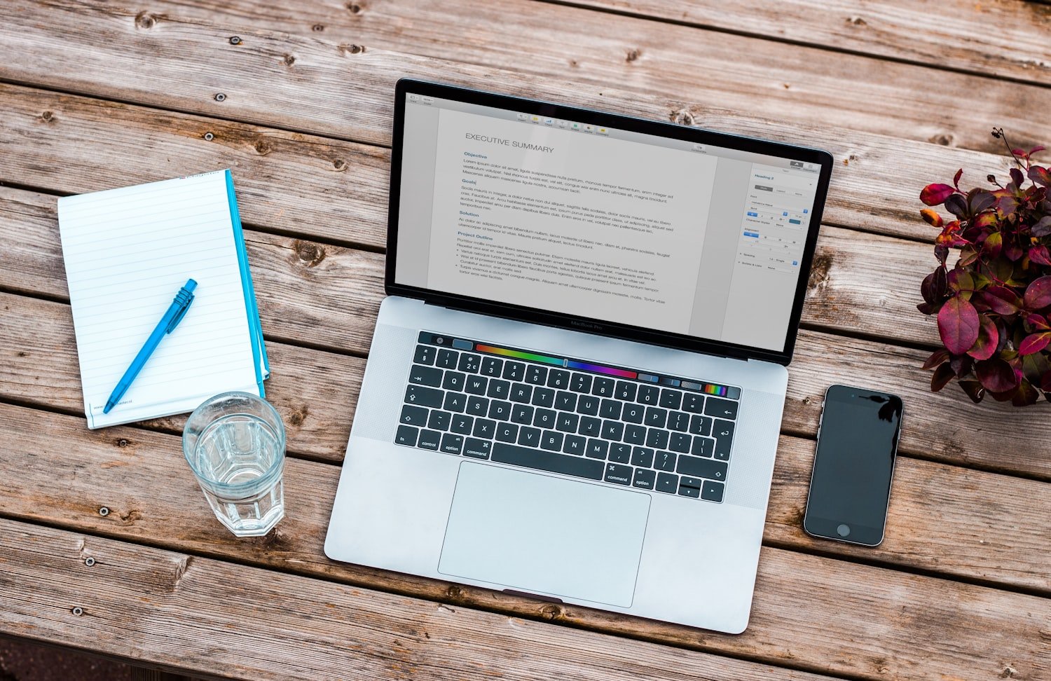 A laptop on a wooden desk, representing a resume and job search