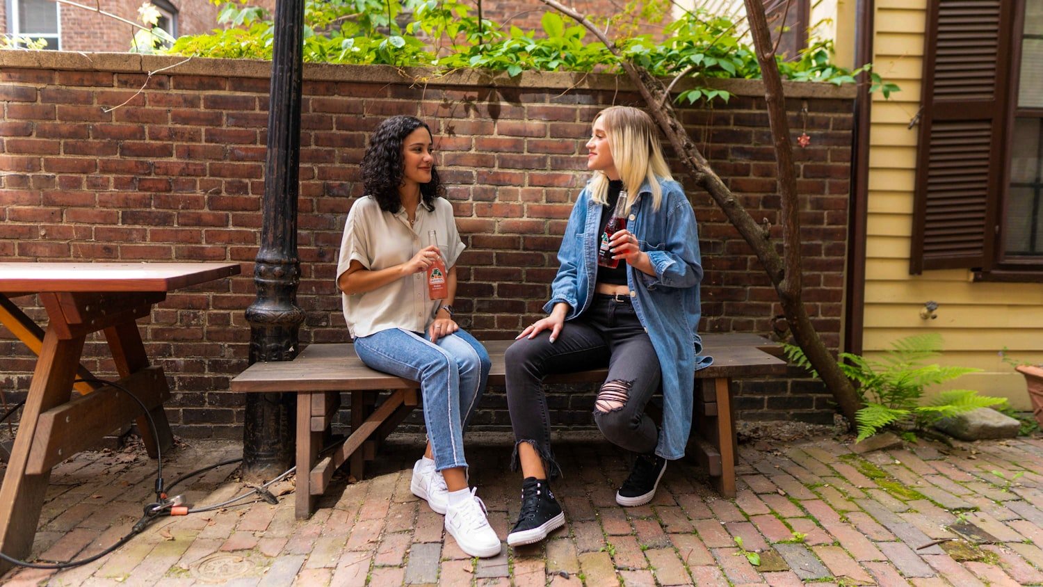 Two people sitting together on a bench in conversation, listening without interrupting