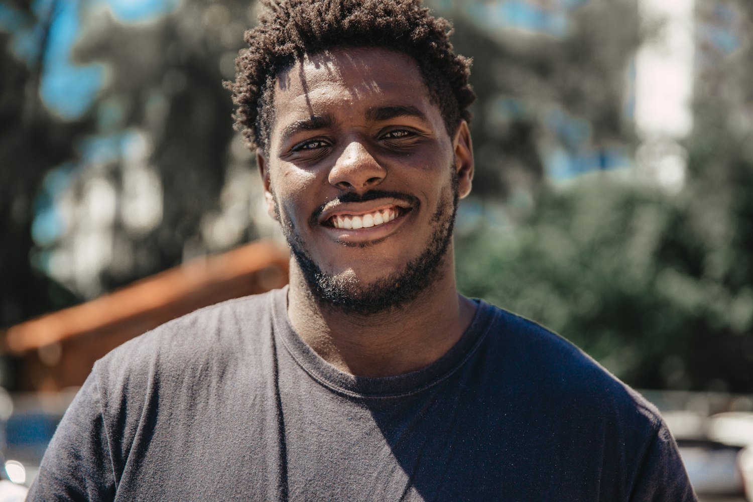 A man smiling outdoors, representing the oral health VA dental benefits are meant to protect