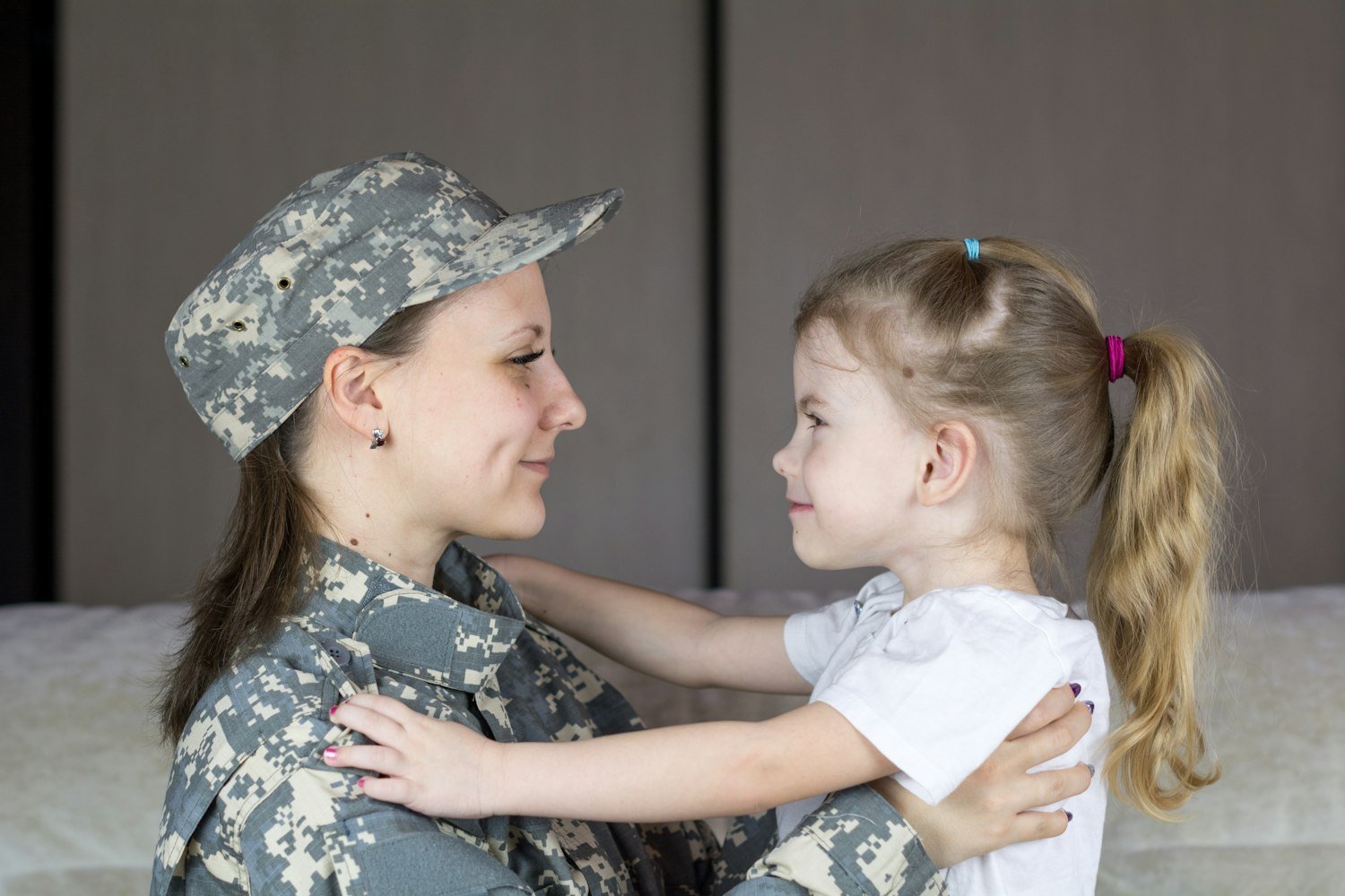 A servicemember embracing a child, representing the military families supported by the American Legion Auxiliary