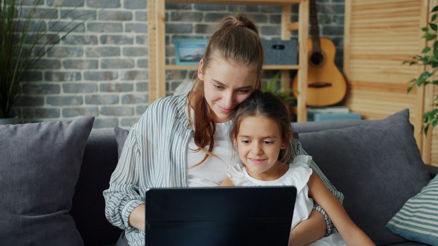 A mother and daughter looking at a laptop together, comparing education benefit options