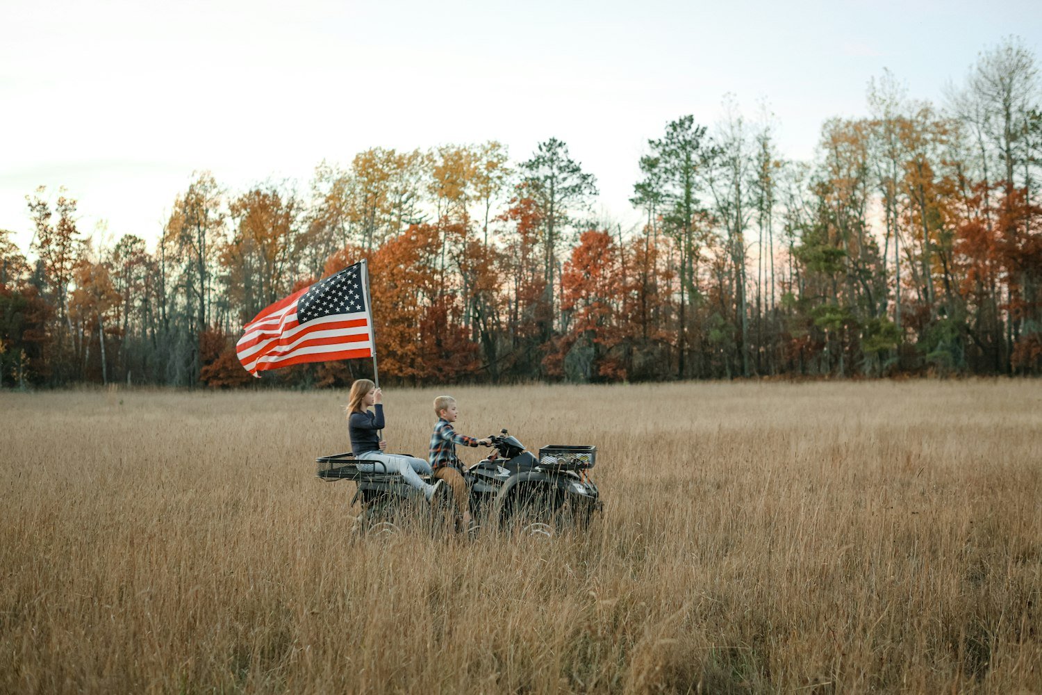 Two motorcycle riders with an American flag, representing the American Legion Riders program
