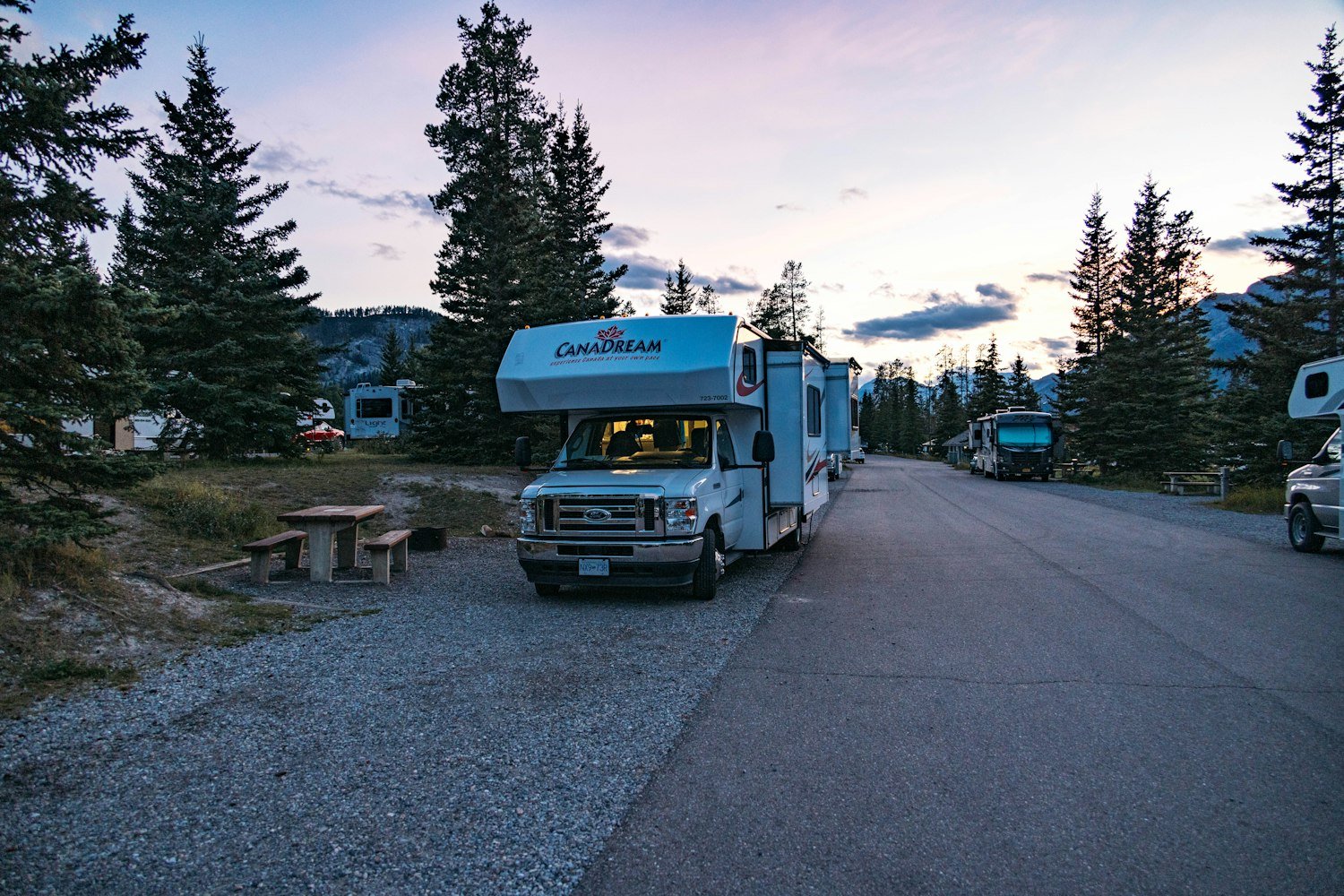 A motorhome parked in a campground at twilight, as at a military recreation RV park