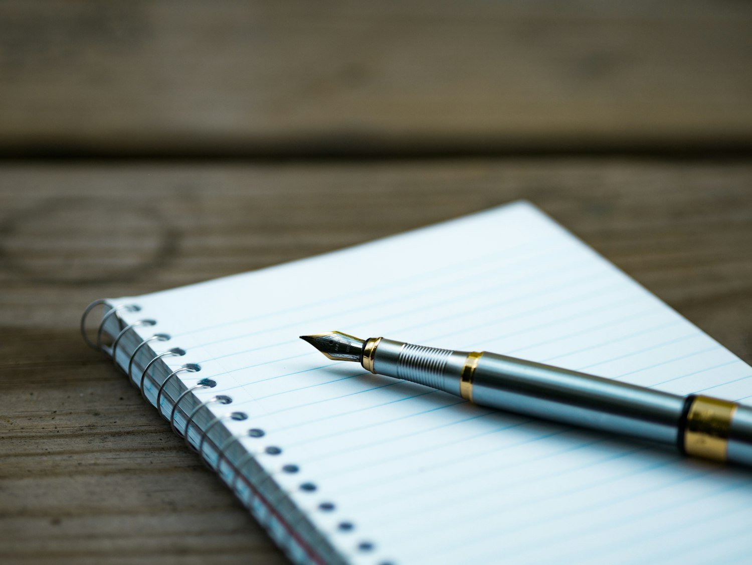 A pen on an open notebook, representing the Adjutant recording meeting minutes