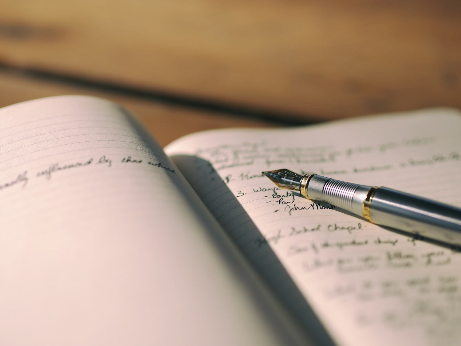 A pen resting on a lined notebook, for recording genealogy research notes