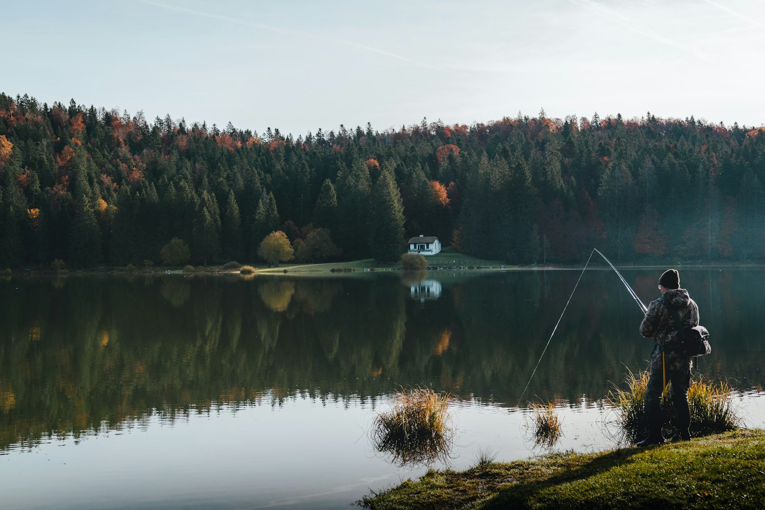 An Oregon lake surrounded by forest, reflecting hunting and fishing license benefits