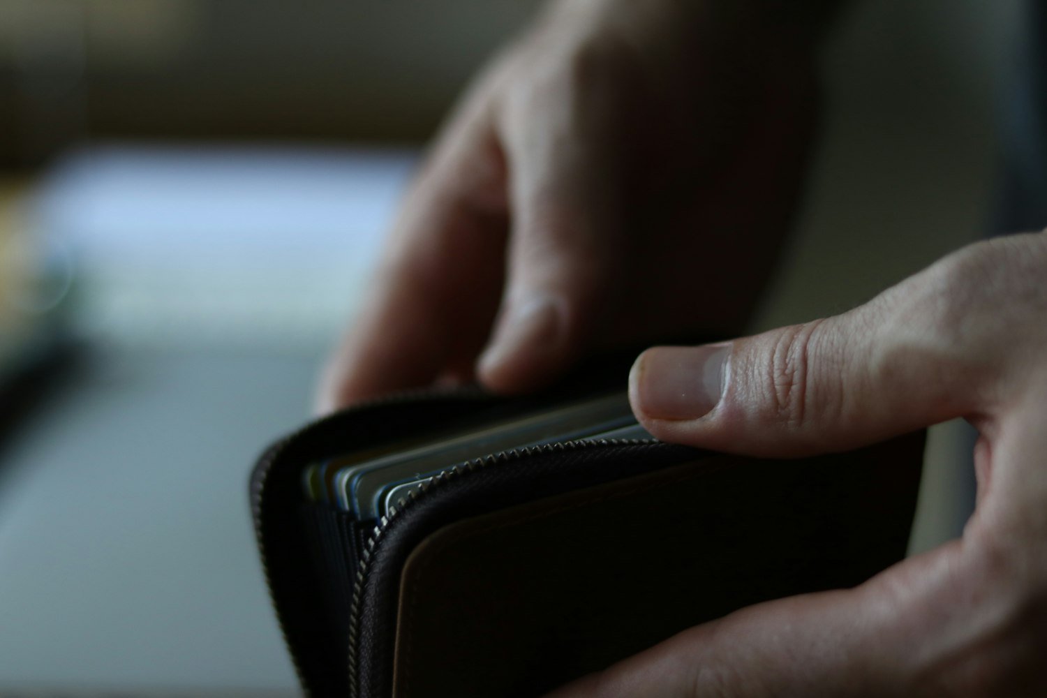A person holding a wallet, representing the small per-trip deductible taken from travel pay