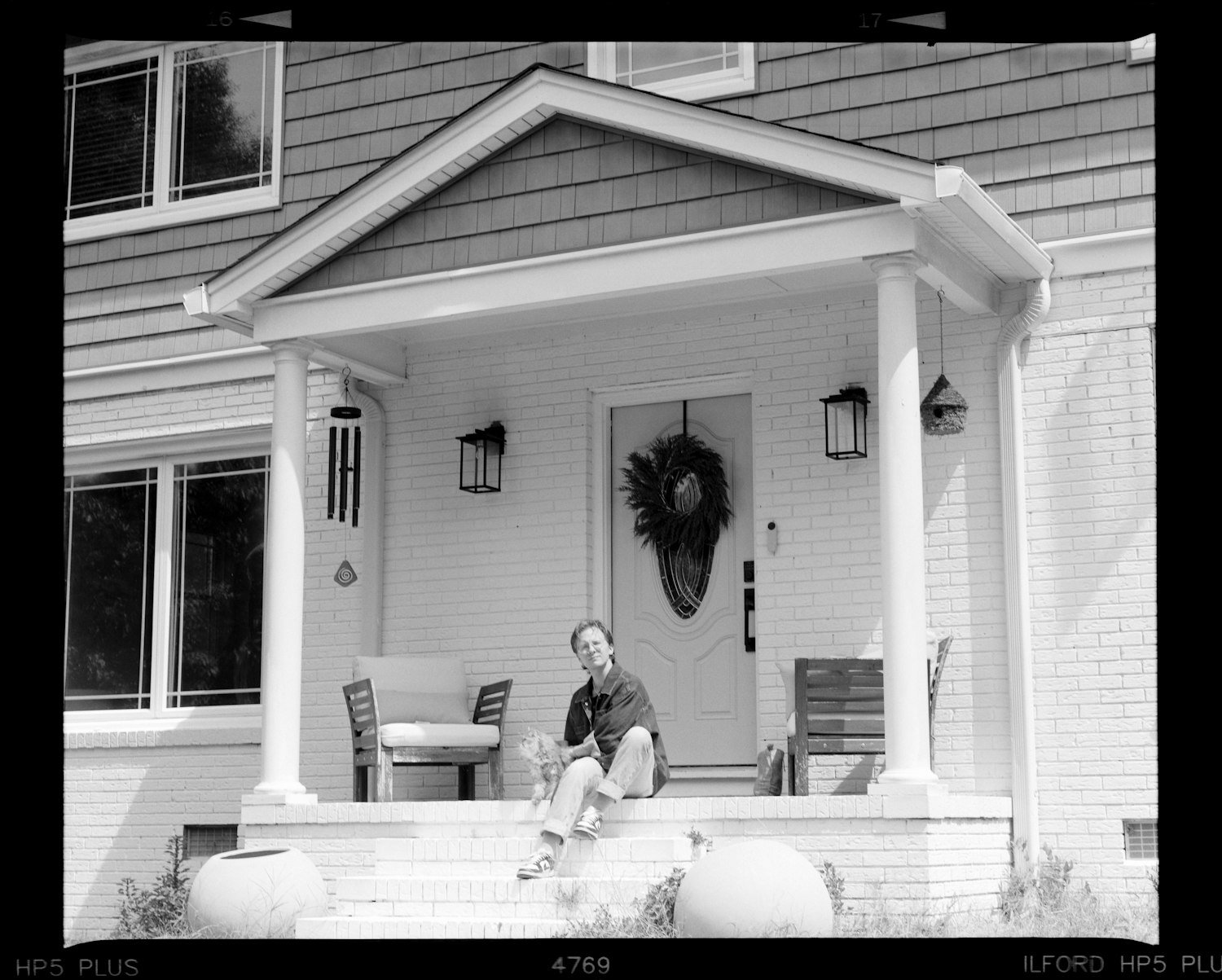 A person sitting on the front porch steps of a house
