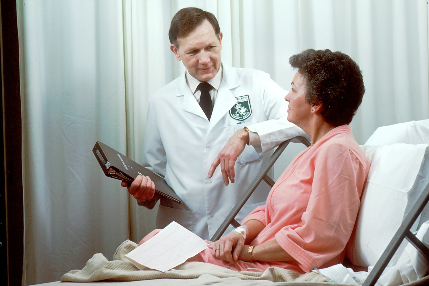 A provider holding a tablet during a clinical interview