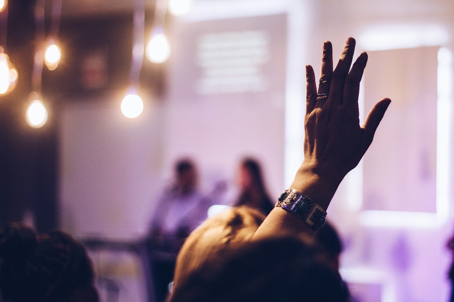 A raised hand during a vote, as when a motion is carried at a post meeting