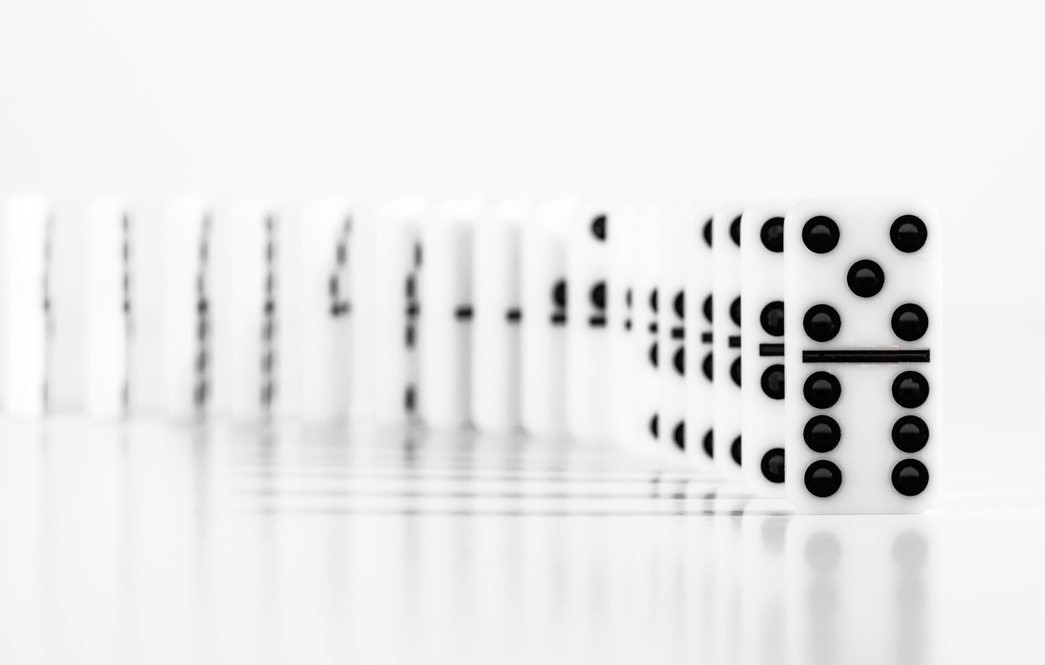 A row of dominoes standing in sequence, illustrating how one condition leads to another
