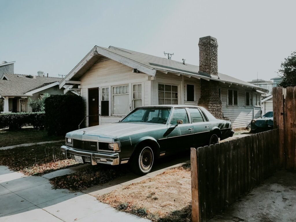 A sedan parked beside a wooden fence