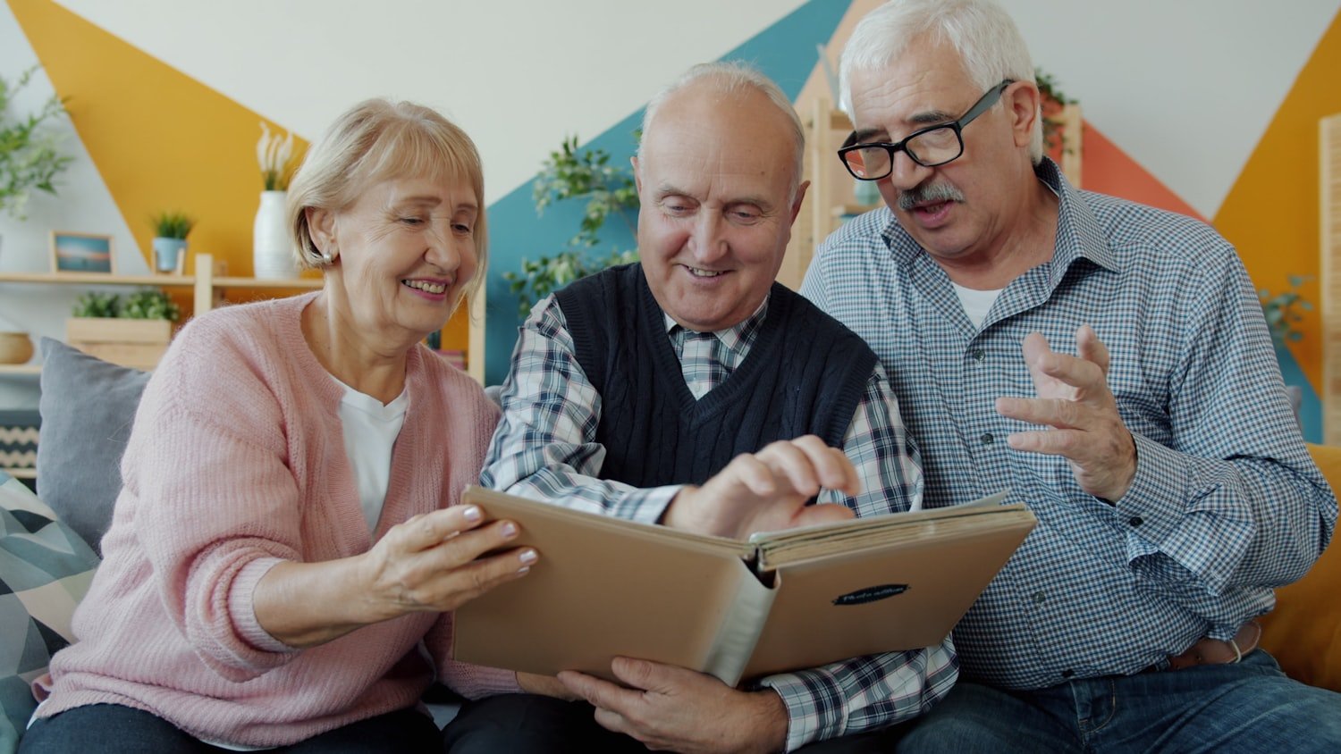 Three seniors looking through a photo album together